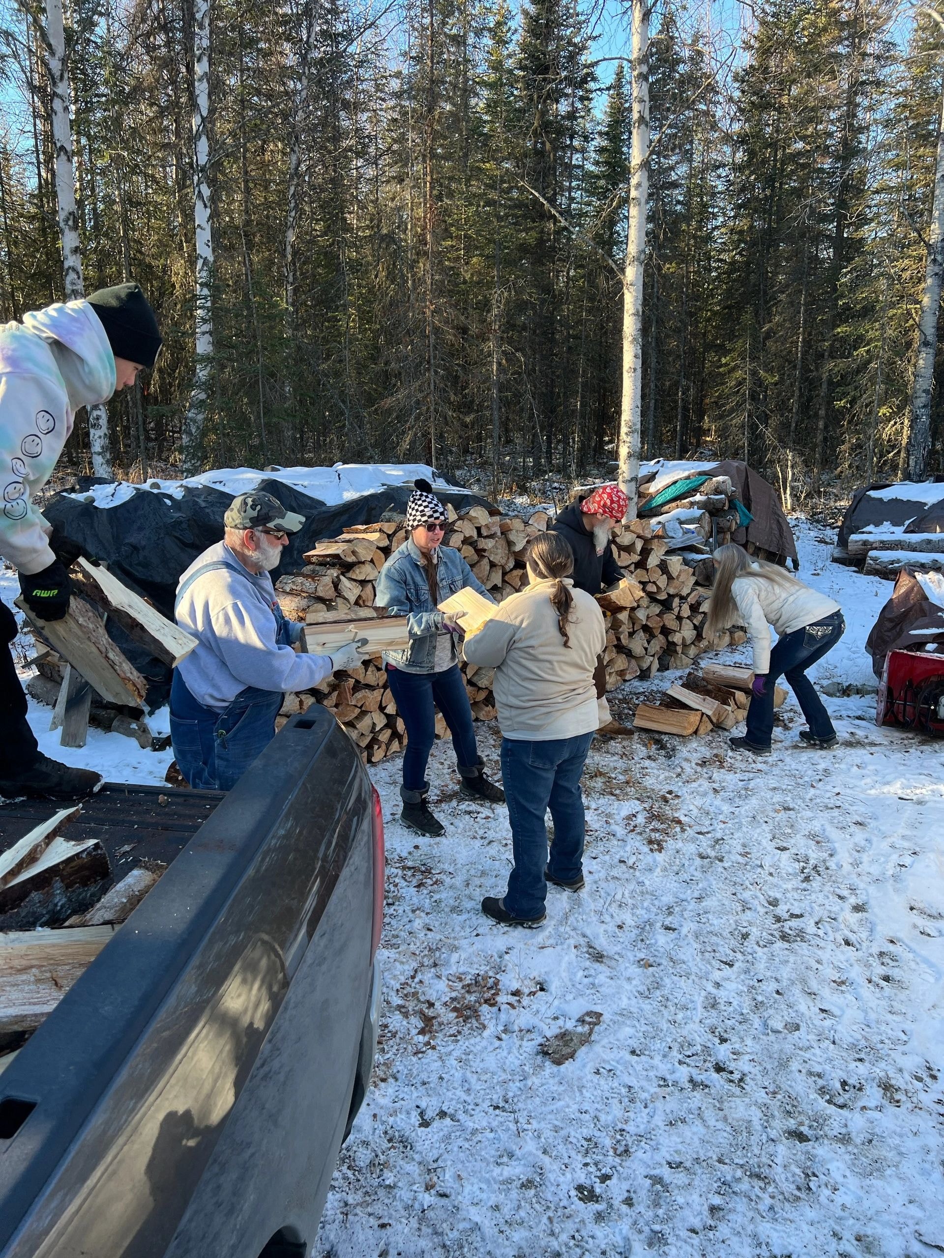 Veterans working together stacking firewood in a community service effort
